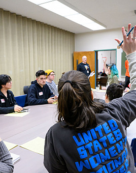 A student raises their hand in Teaching for Social Justice with Associate Professor Maika Yeigh.