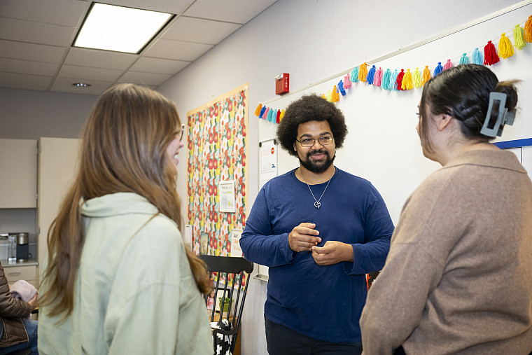 Graduate students engage with each other at a K-12 school.
