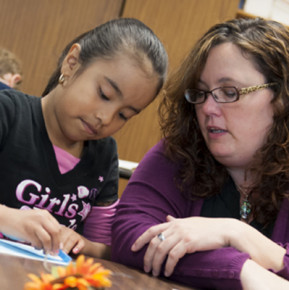 A teacher candidate works with a student during her practicum experience.