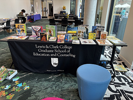 A table is laid out with books and activities, ready to welcome children and families to read, play games, and make art.