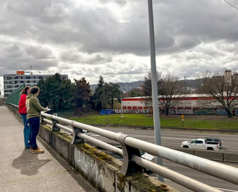Aidan Hanley, left, and Cooper Bulens, right, take notes of their observations on an overpass over Interstate 5 during a place-based less...