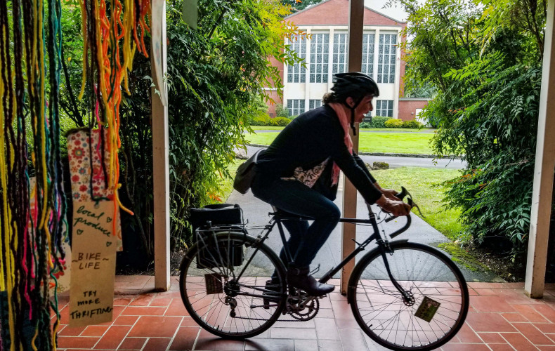 A cyclist passes in front of York on the graduate campus.