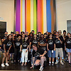 Group of people wearing matching black tshirts.