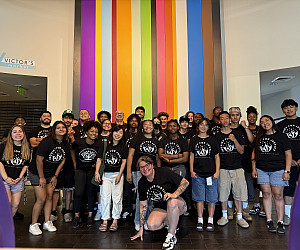 Group of people wearing matching black tshirts.